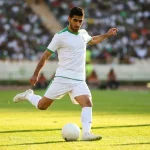 Joueur iranien en maillot blanc en action sur le terrain de football
