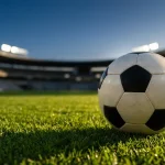 Ballon de football posé sur la pelouse d'un stade belge au coucher du soleil
