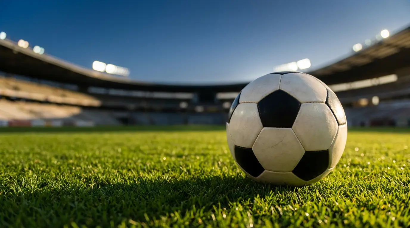 Ballon de football posé sur la pelouse d'un stade belge au coucher du soleil