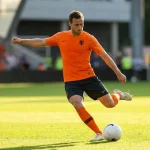 Joueur néerlandais en maillot orange en action sur une pelouse